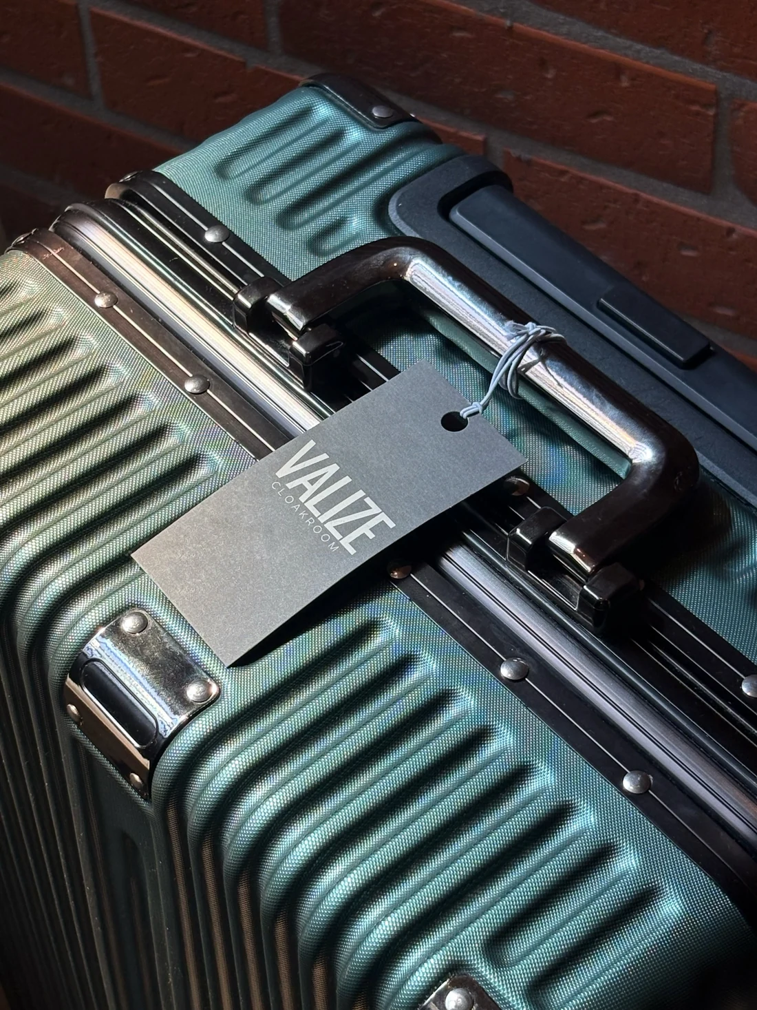 An original VALIZE Cloakroom tag attached to luggage