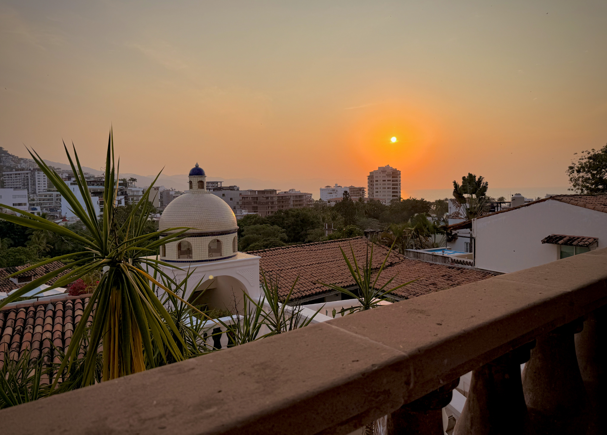 Sunset over Puerto Vallarta rooftops and the bay, viewed from the Iguana